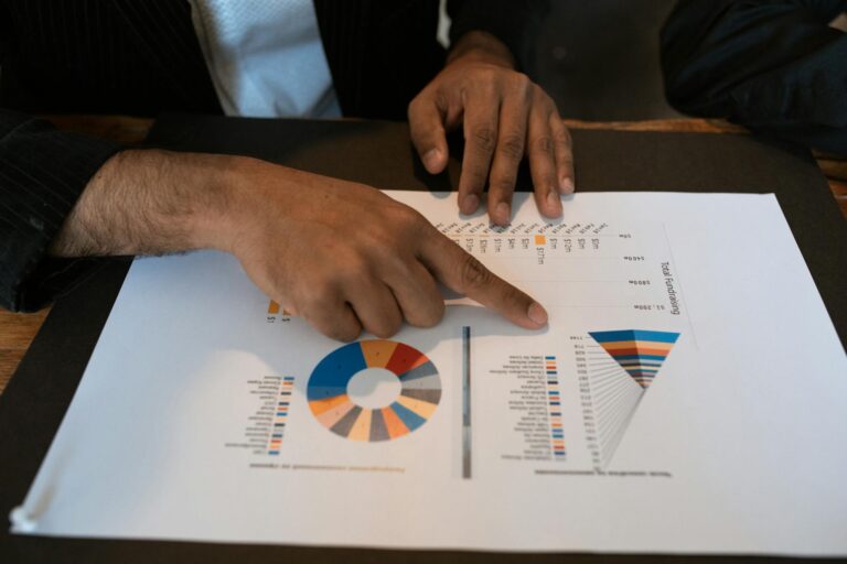 Photo by RDNE Stock project - BizRanger Hub Hands pointing at colorful graphs and charts in a workspace. Ideal for business presentations and reports.
